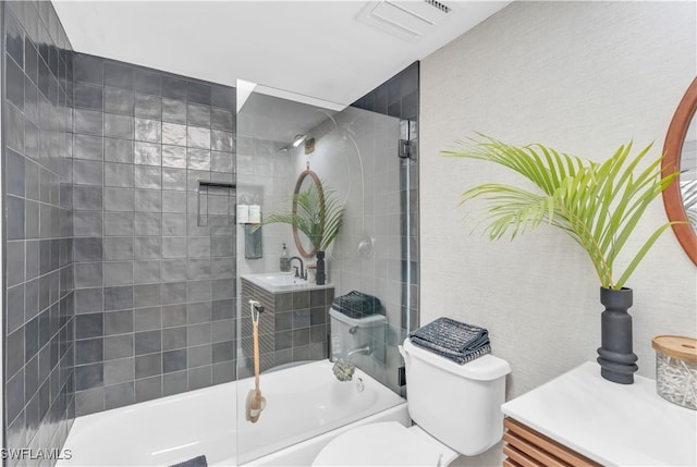 full bathroom featuring tiled shower / bath combo, vanity, and toilet