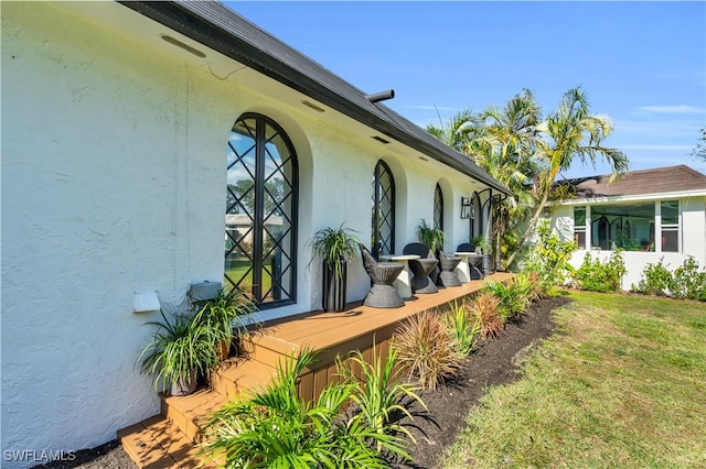 view of side of home featuring a sunroom and a yard