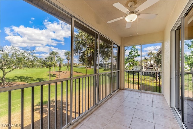 unfurnished sunroom featuring ceiling fan