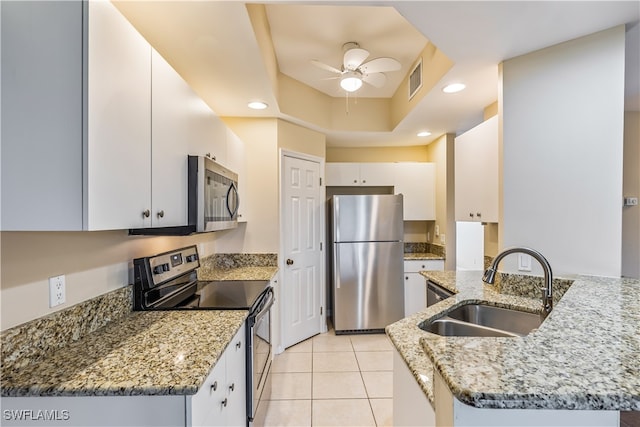 kitchen featuring stainless steel appliances, light stone counters, white cabinets, kitchen peninsula, and sink