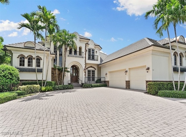 view of front of property with a garage, a balcony, and french doors