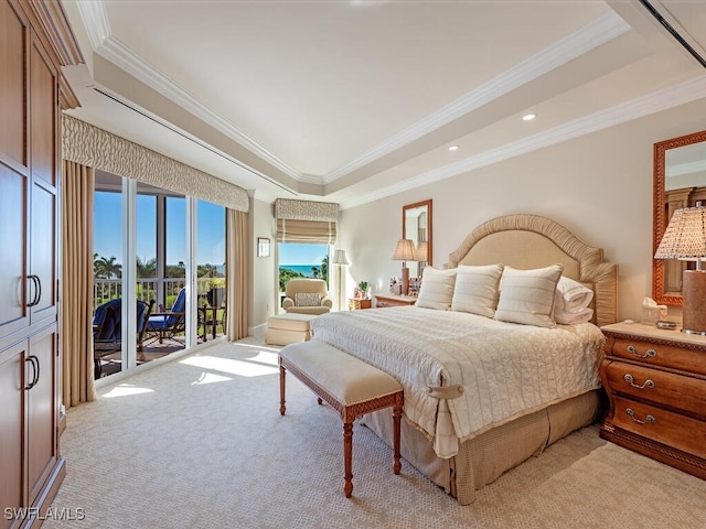 carpeted bedroom featuring access to exterior, a tray ceiling, and ornamental molding