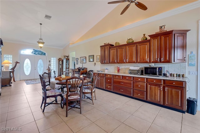 kitchen featuring light tile patterned flooring, ceiling fan, backsplash, and ornamental molding