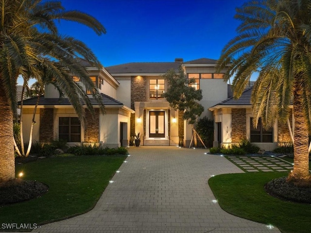 319 Devils Bight, Naples, FL 34103 - view of front of home featuring stucco siding, decorative driveway, stone siding, and a front yard