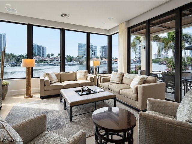 living room featuring a healthy amount of sunlight and a water view