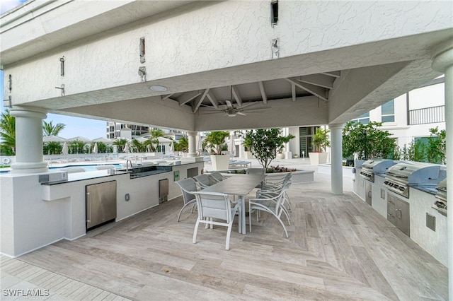 view of patio / terrace featuring a gazebo, ceiling fan, exterior kitchen, and grilling area