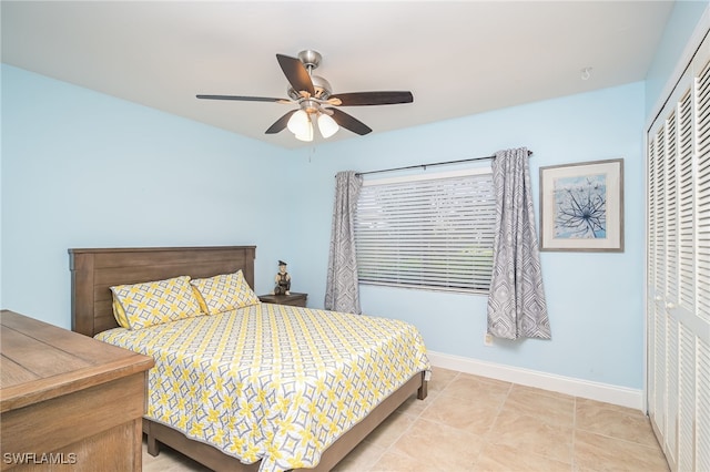 bedroom featuring light tile patterned flooring, ceiling fan, and a closet