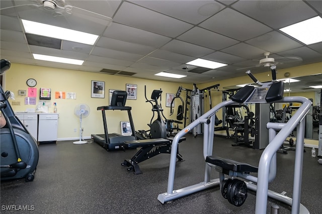 workout area featuring a paneled ceiling and ceiling fan