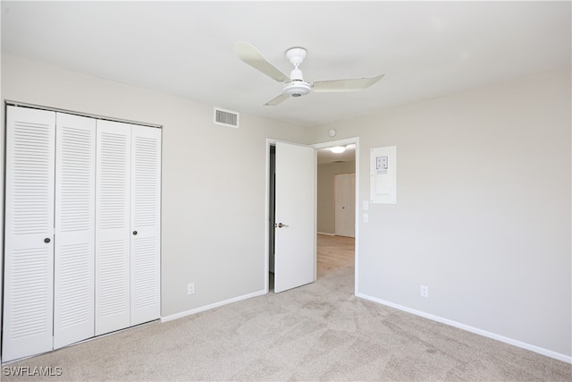 unfurnished bedroom with ceiling fan, light colored carpet, and a closet