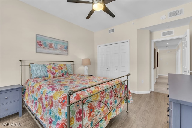 bedroom featuring light hardwood / wood-style floors, ceiling fan, and a closet