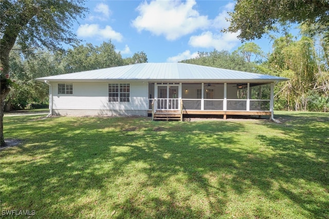 back of property with a lawn and a sunroom