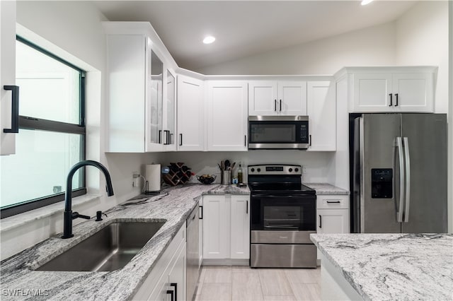 kitchen featuring white cabinetry, sink, stainless steel appliances, and light stone counters