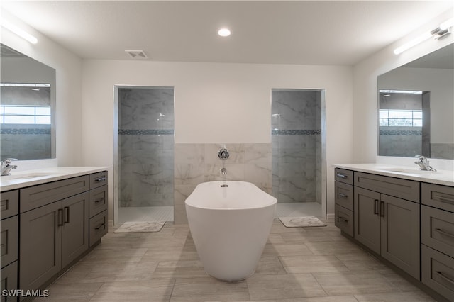 bathroom featuring vanity, separate shower and tub, and a wealth of natural light