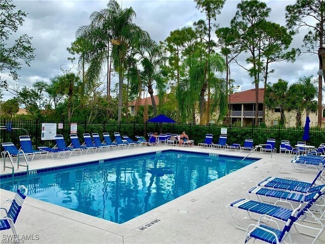 517 Robin Hood Cir Unit 102, Naples, FL 34104 - community pool featuring fence and a patio
