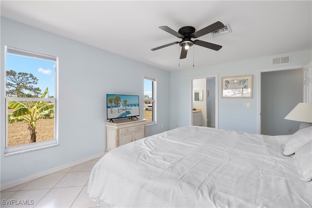 bedroom featuring ceiling fan, ensuite bath, and light tile patterned floors