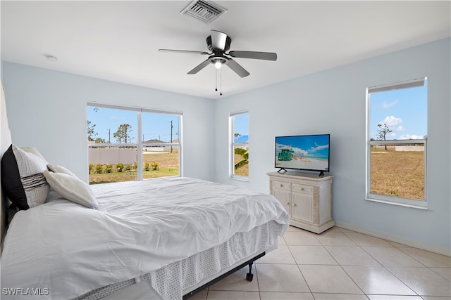 tiled bedroom featuring multiple windows and ceiling fan