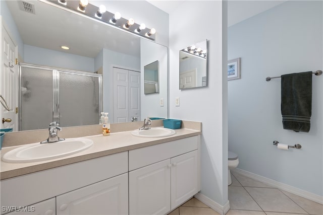 bathroom with walk in shower, vanity, tile patterned flooring, and toilet