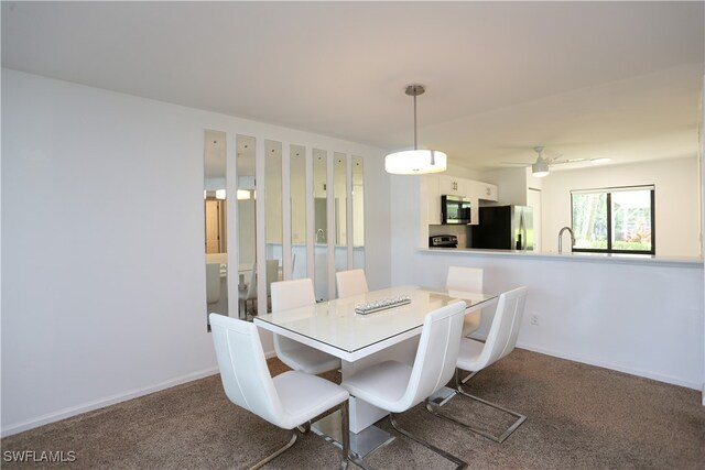 dining room featuring ceiling fan, carpet flooring, and sink