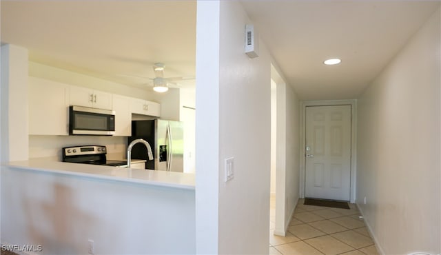 kitchen featuring stainless steel appliances, white cabinets, ceiling fan, and light tile patterned floors