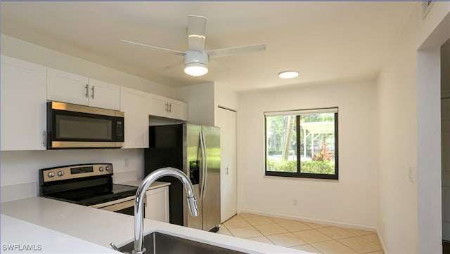 kitchen featuring light tile patterned floors, ceiling fan, stainless steel appliances, and white cabinets