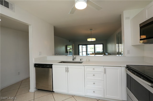 kitchen with appliances with stainless steel finishes, light tile patterned flooring, white cabinets, ceiling fan, and sink