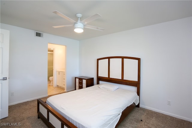 bedroom with light carpet, ensuite bath, and ceiling fan