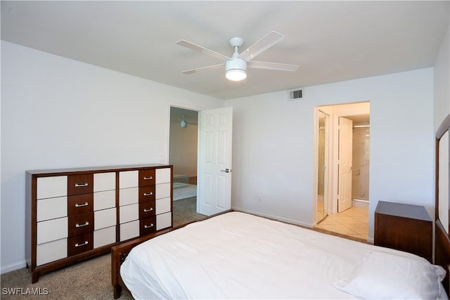 carpeted bedroom featuring ensuite bath and ceiling fan