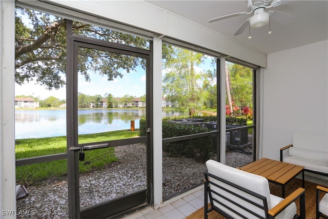 sunroom / solarium featuring ceiling fan and a water view