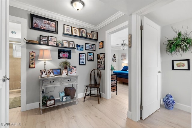 hall with ornamental molding and light hardwood / wood-style floors