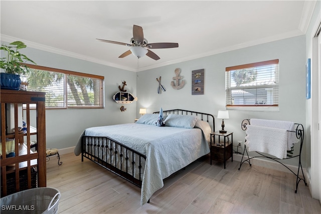 bedroom featuring light wood-type flooring, multiple windows, and ceiling fan