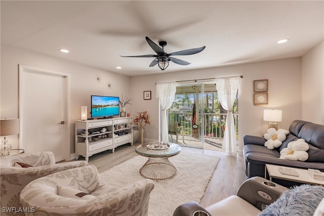 living room featuring light wood-type flooring and ceiling fan