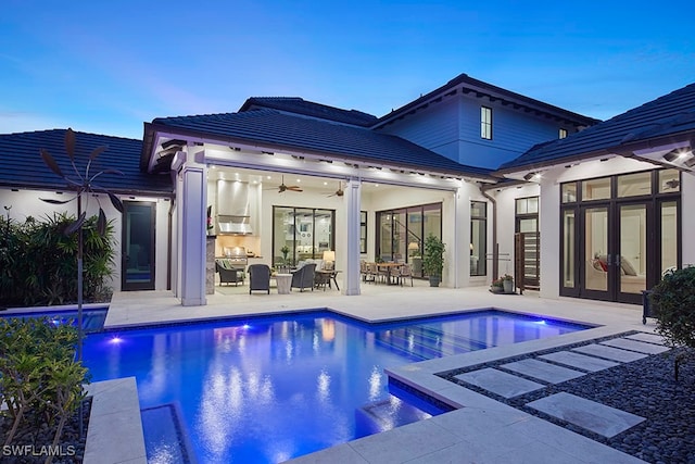 pool at dusk with ceiling fan, a patio, a jacuzzi, and grilling area