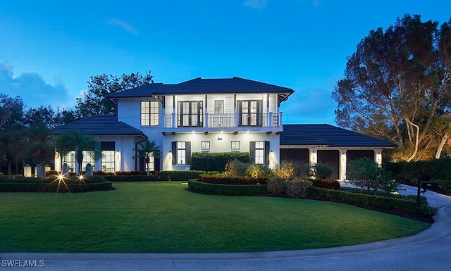 view of front of house featuring a balcony and a yard