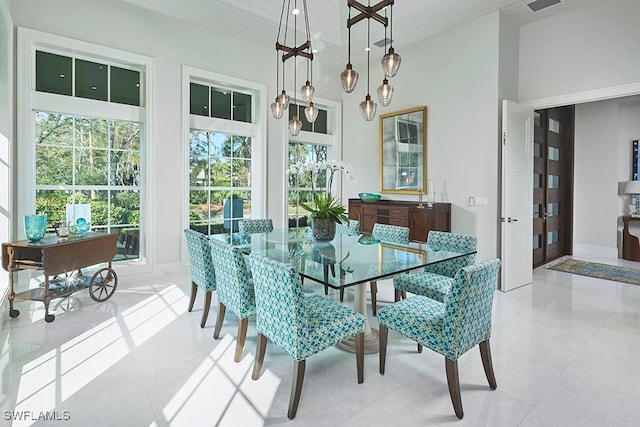 dining space featuring a towering ceiling, light tile patterned floors, and french doors