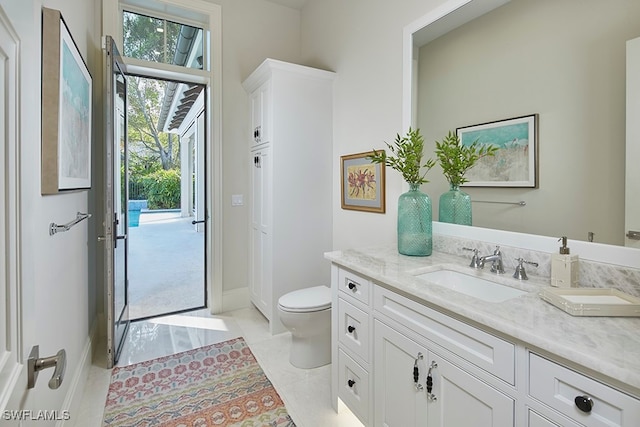 bathroom featuring tile patterned flooring, vanity, and toilet