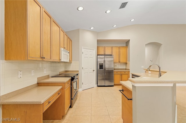 kitchen with light tile patterned floors, sink, appliances with stainless steel finishes, vaulted ceiling, and decorative backsplash