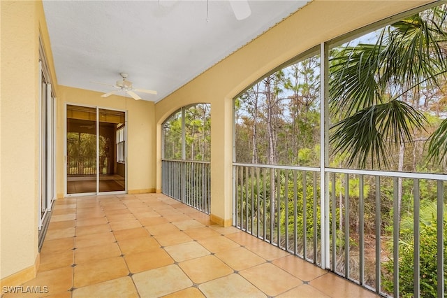 unfurnished sunroom with ceiling fan