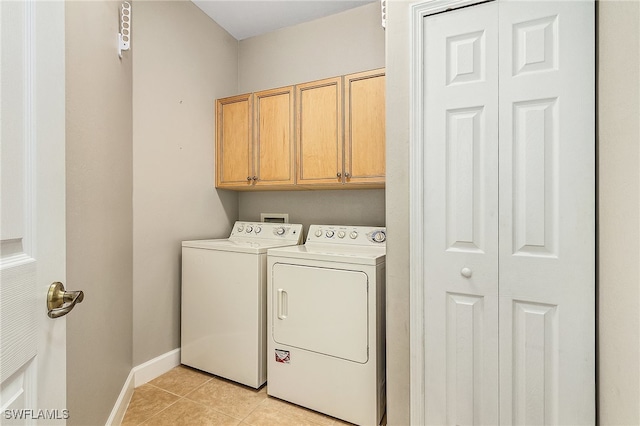 laundry area with cabinets, washer and dryer, and light tile patterned flooring