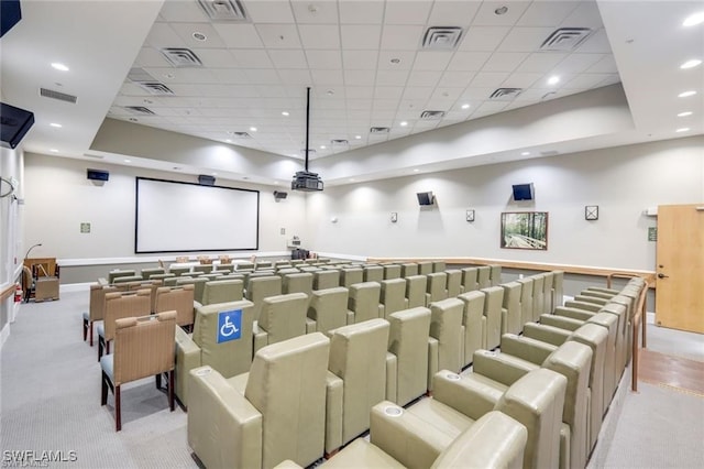 home theater room featuring light colored carpet, a raised ceiling, and a paneled ceiling