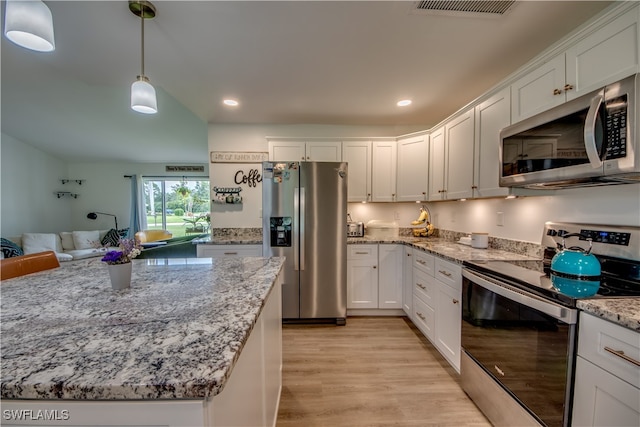 kitchen with pendant lighting, light hardwood / wood-style floors, white cabinets, appliances with stainless steel finishes, and light stone countertops