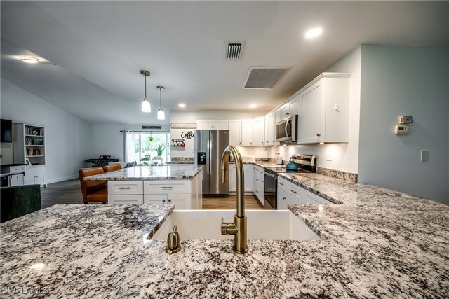 kitchen featuring pendant lighting, sink, white cabinetry, stainless steel appliances, and dark hardwood / wood-style flooring