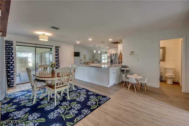 dining space with light hardwood / wood-style floors and sink