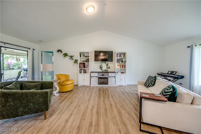 living room with light hardwood / wood-style flooring and vaulted ceiling