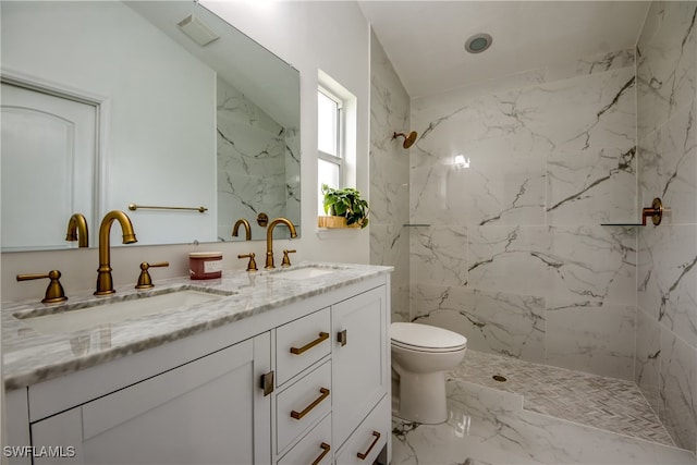 bathroom featuring vanity, a tile shower, and toilet