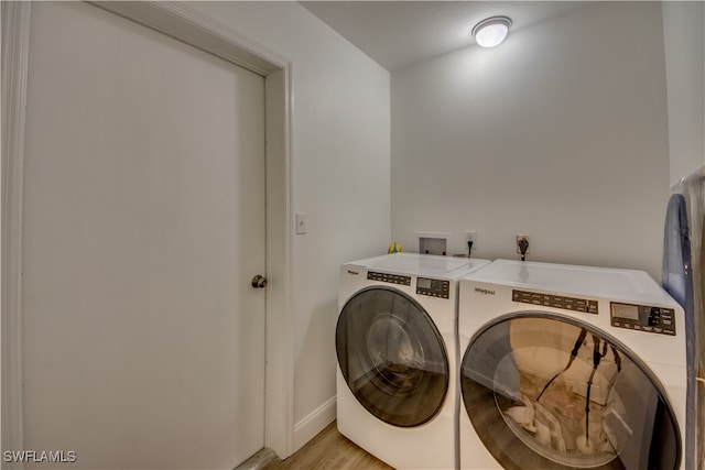 laundry room featuring light wood-type flooring and washer and clothes dryer