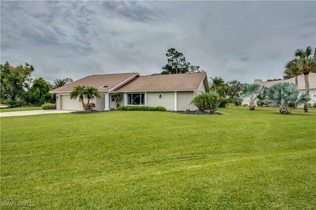 ranch-style home featuring a garage and a front lawn