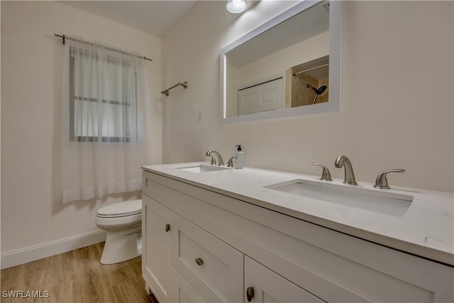 bathroom featuring walk in shower, vanity, toilet, and hardwood / wood-style flooring