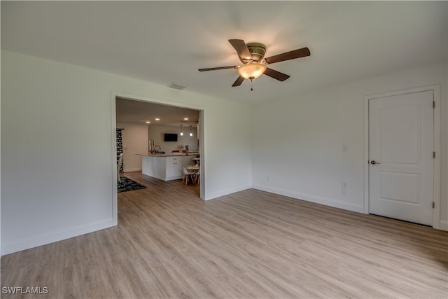 unfurnished living room with light wood-type flooring and ceiling fan