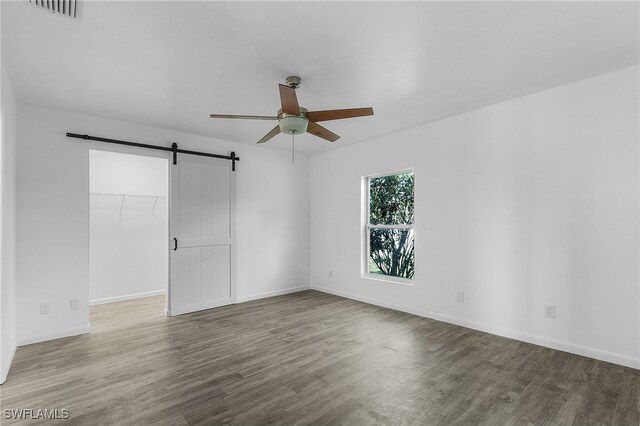 1905 SW 11th St, Cape Coral, FL 33991 - empty room with a ceiling fan, a barn door, wood finished floors, and baseboards