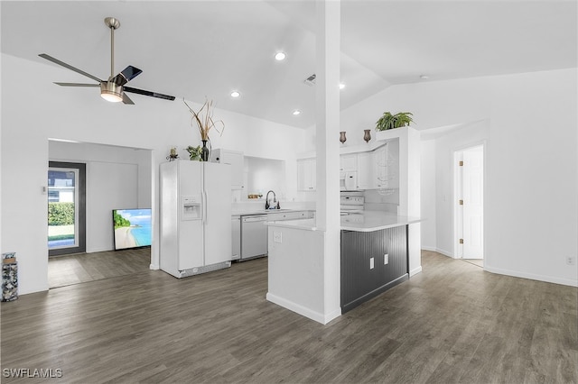 kitchen with white appliances, kitchen peninsula, vaulted ceiling, dark hardwood / wood-style flooring, and white cabinetry